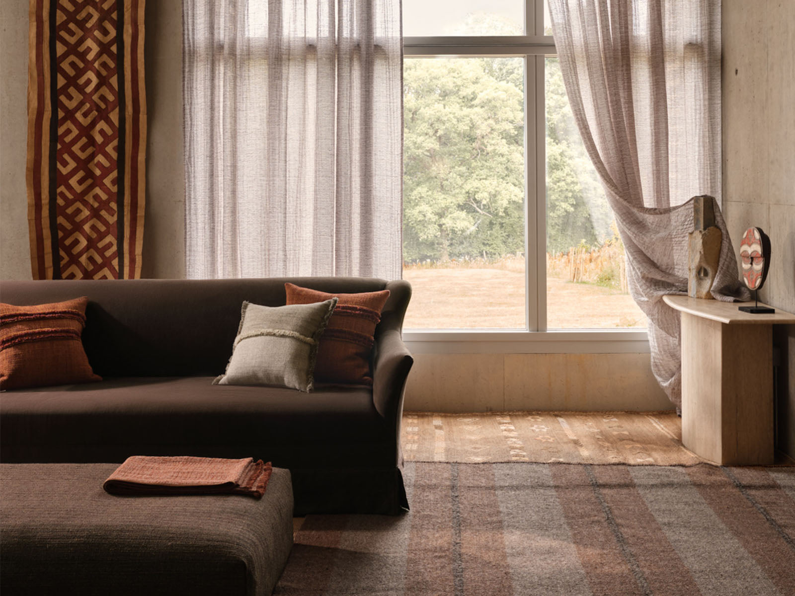 de Le Cuona fabrics—Chuckka Gorilla, Strata Ember, ForageCloth Gull, Strata Cinder—styled in layered interior.
