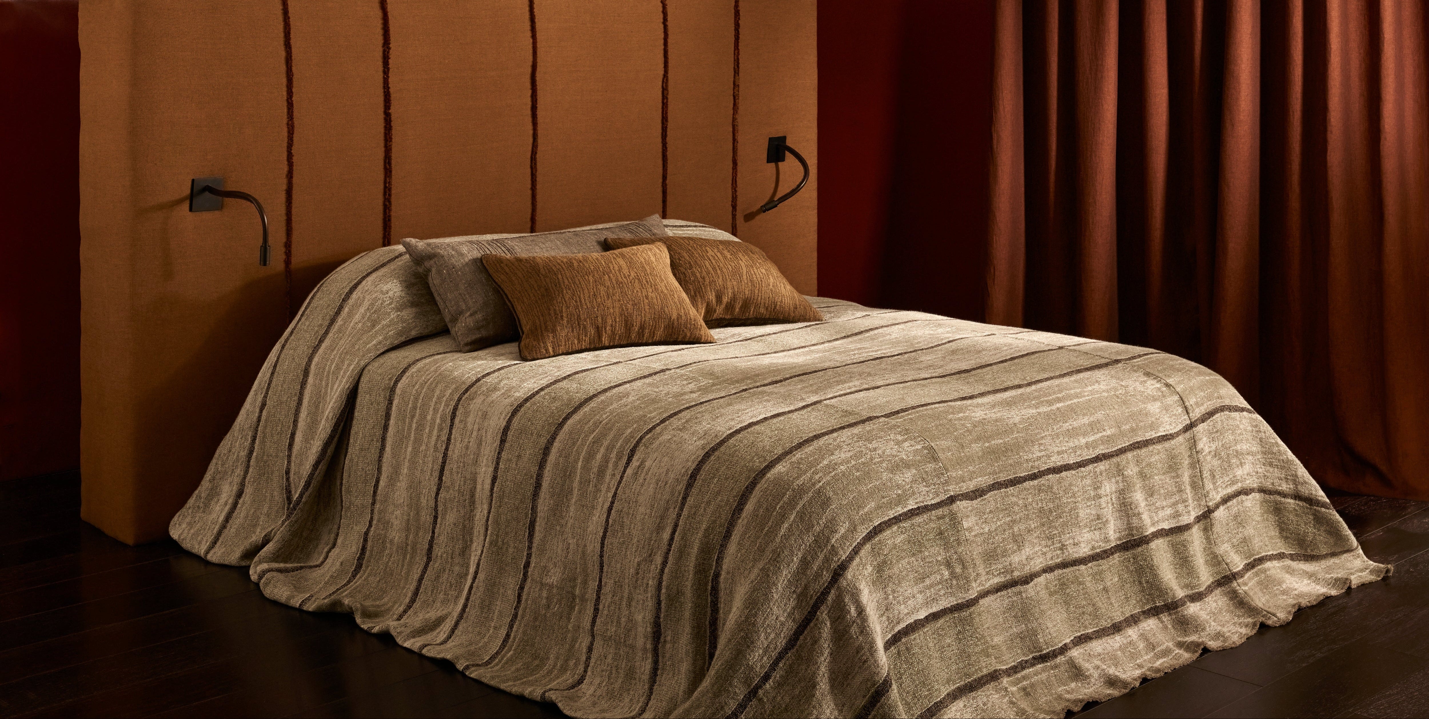 Bed with brown headboard and bedding in a dimly lit room
