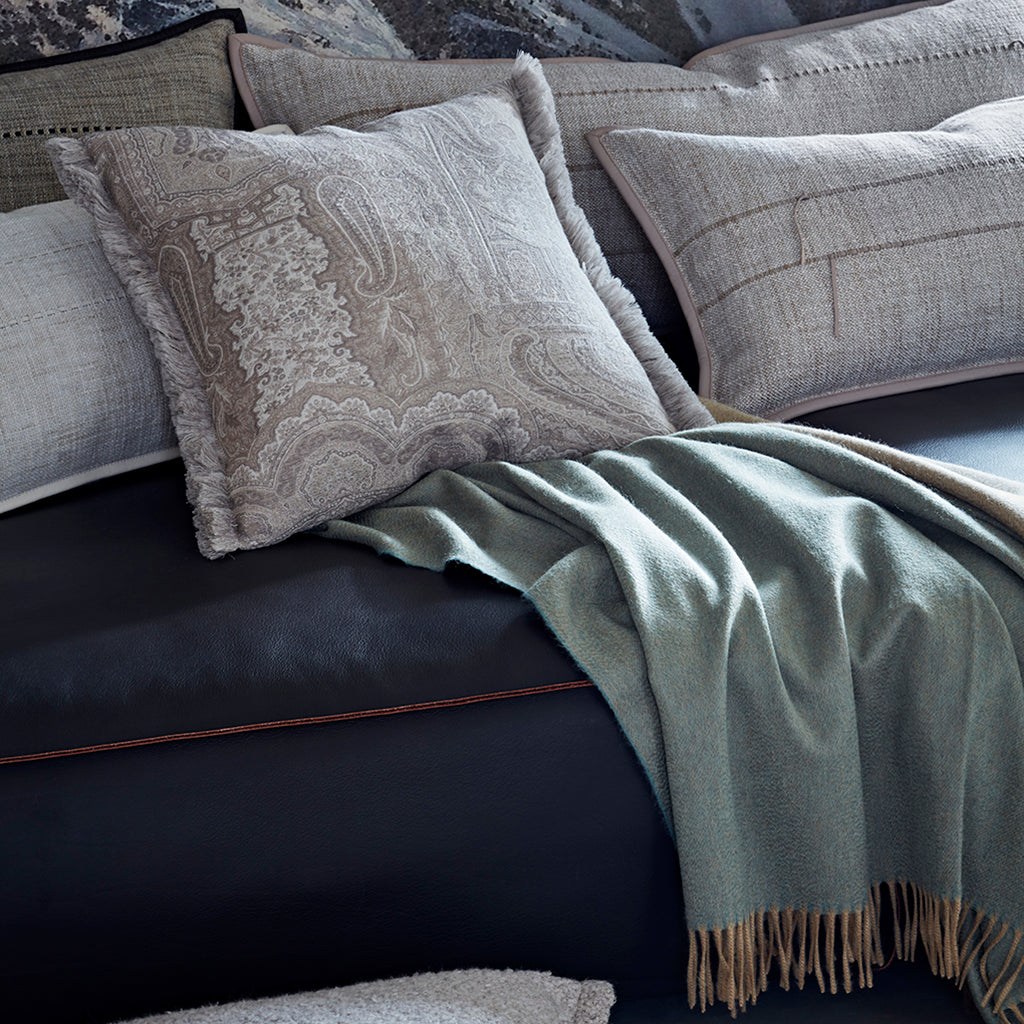 Gray textured cushions and blanket on a dark sofa