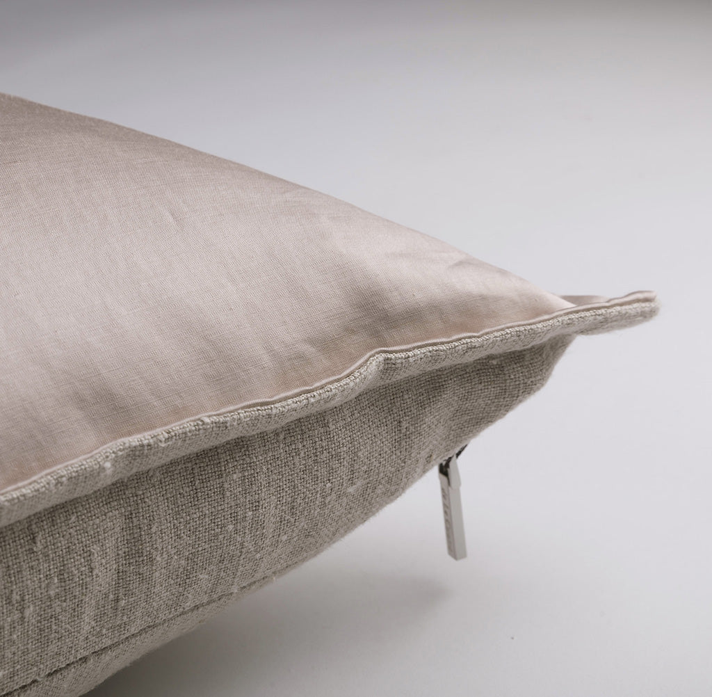 Textured beige cushion on a light gray background