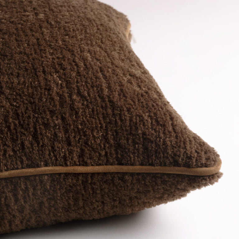Brown textured wool fur cushion on a white background