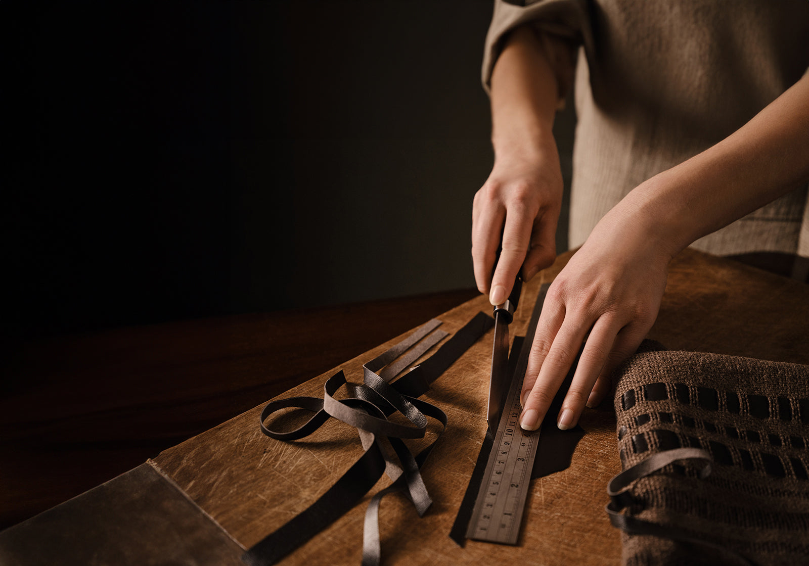 de Le Cuona Fox Ash fabric with hand-woven leather detail—luxury textile showcasing artisanal craftsmanship.