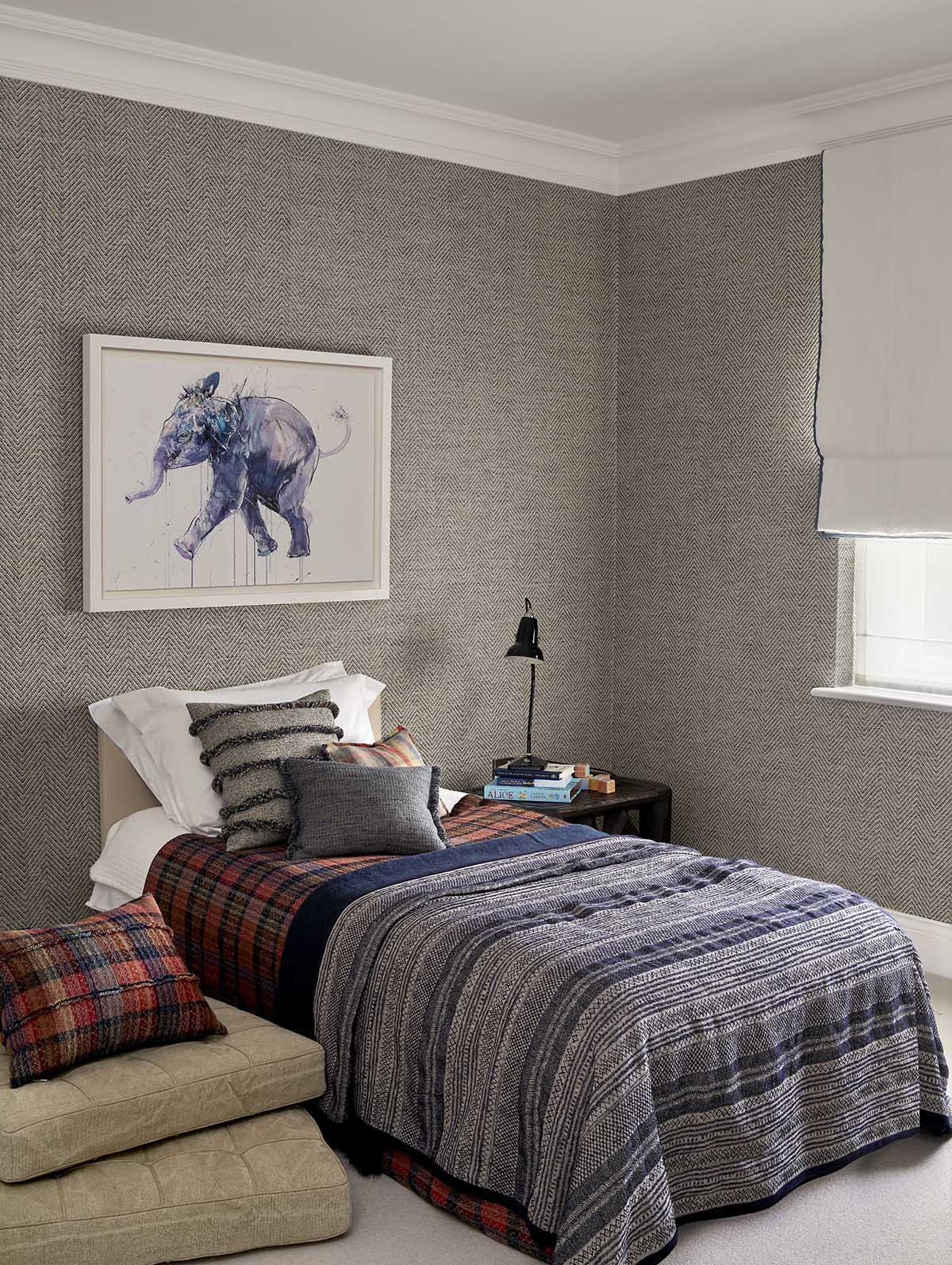 Bedroom with gray walls, a bed with plaid and striped bedding, and a framed elephant artwork.