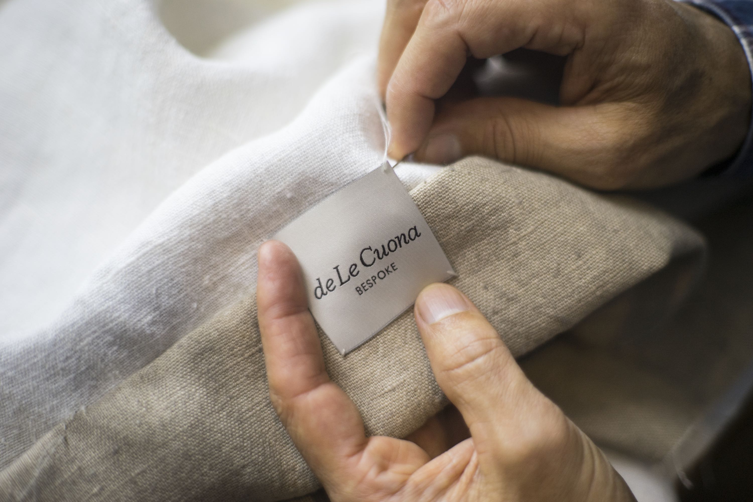 de Le Cuona artisan working with textiles—showcasing luxury fabric craftsmanship and heritage techniques.
