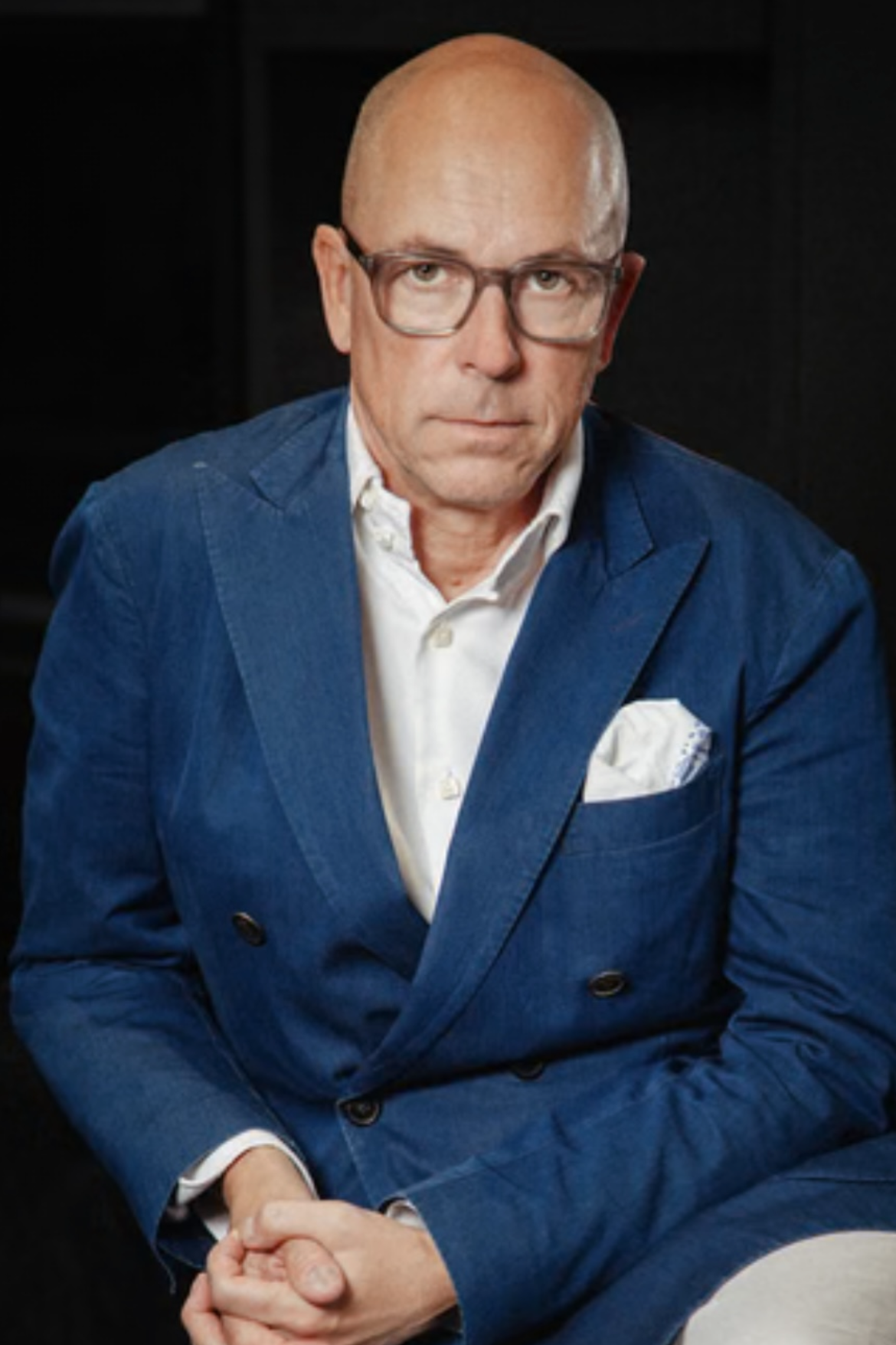 Man in a blue suit with text about a conversation with Dylan Jones and James Mullinger