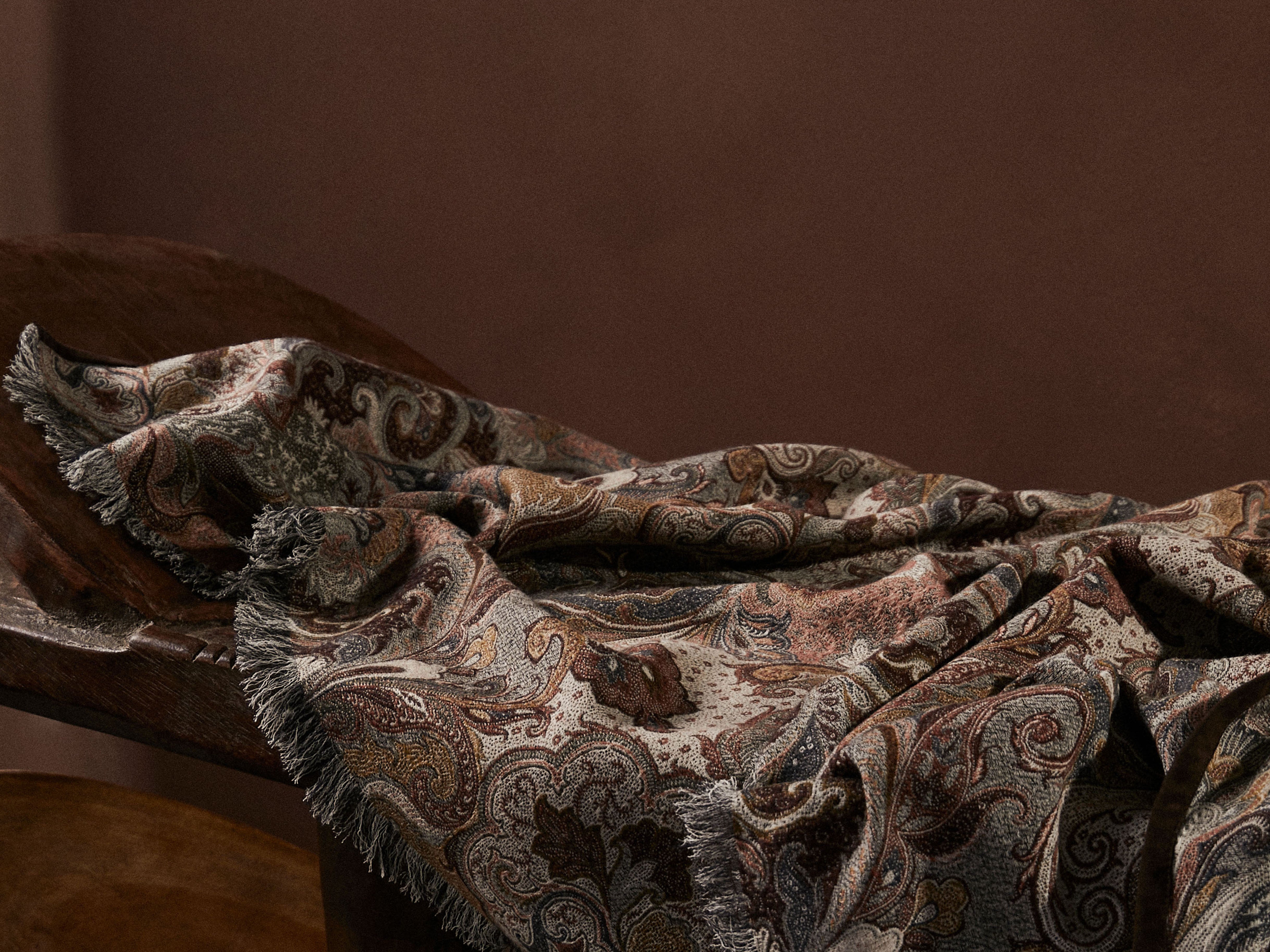 de Le Cuona Elizabeth Throw in Pheasant—luxury fringe and suede-edged textile styled in a cozy interior.
