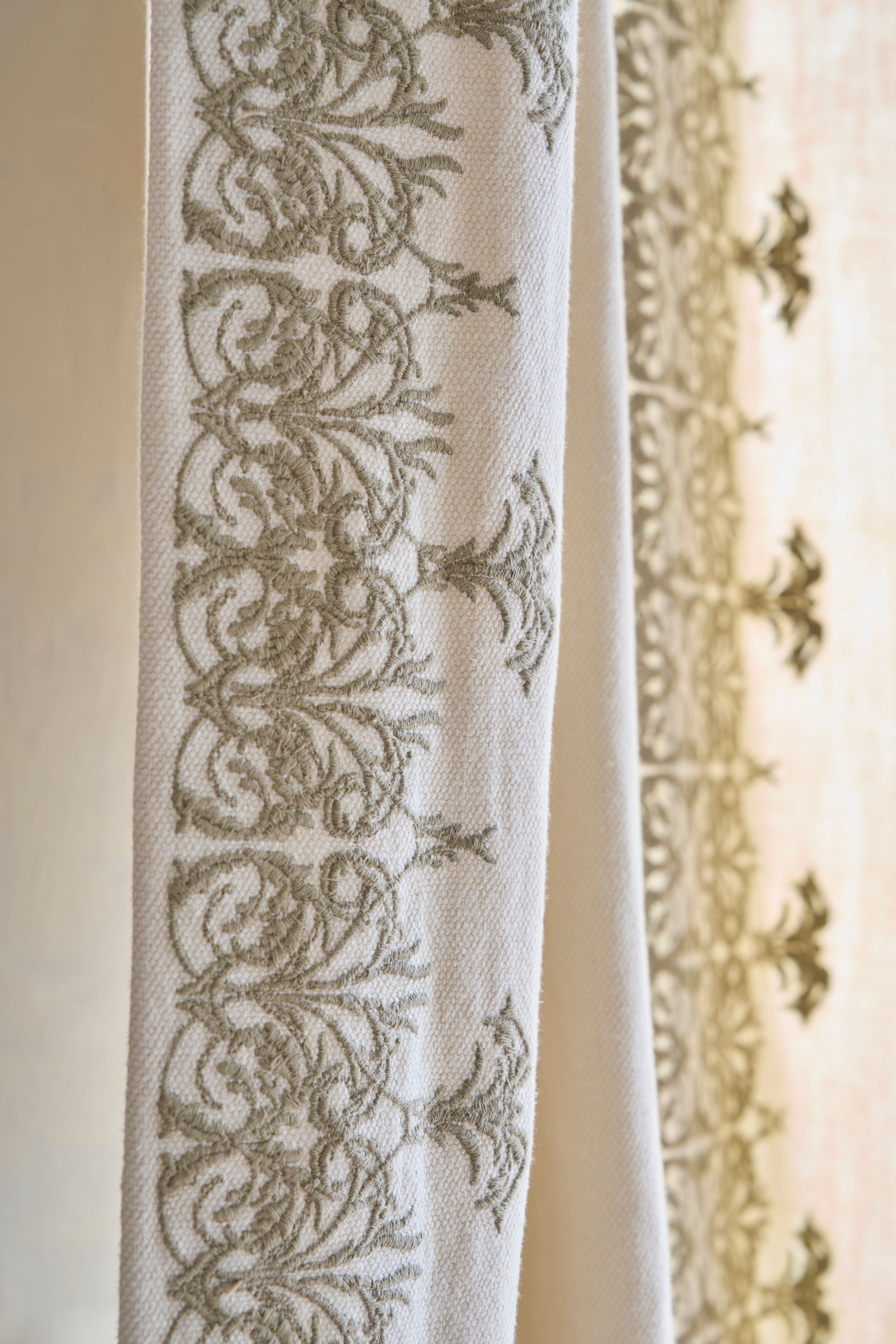 de Le Cuona fabrics—TAN2 and V4—styled in a refined interior with layered textures and natural color palette.
