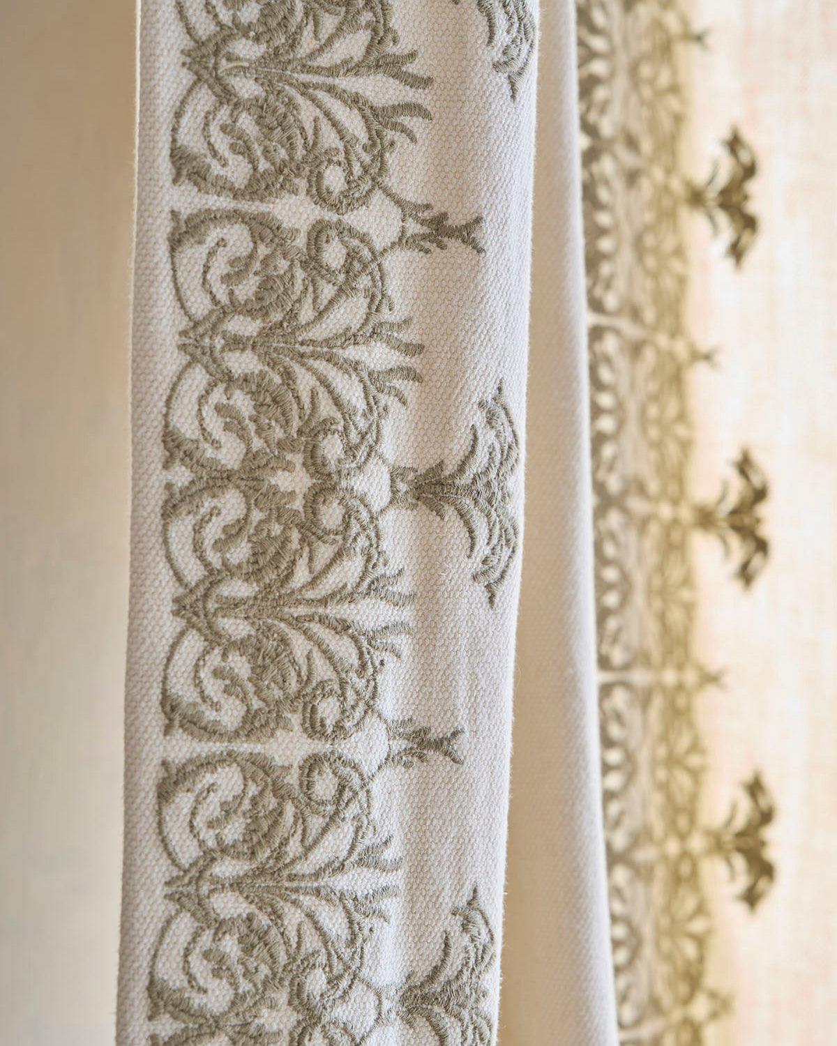 de Le Cuona fabrics—TAN2 and V4—styled in a refined interior with layered textures and natural color palette.
