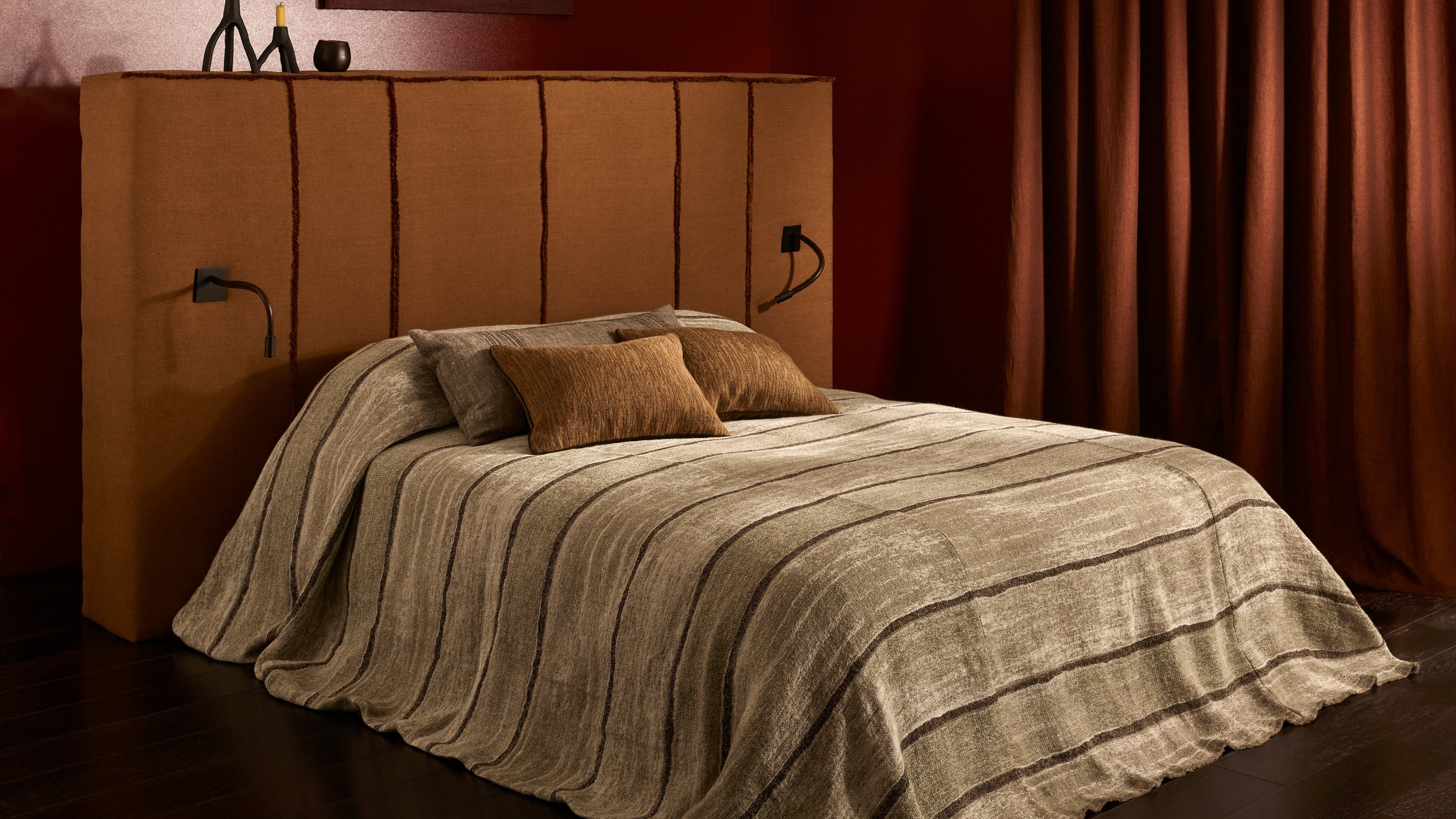 Bed with brown headboard and bedding in a dimly lit room