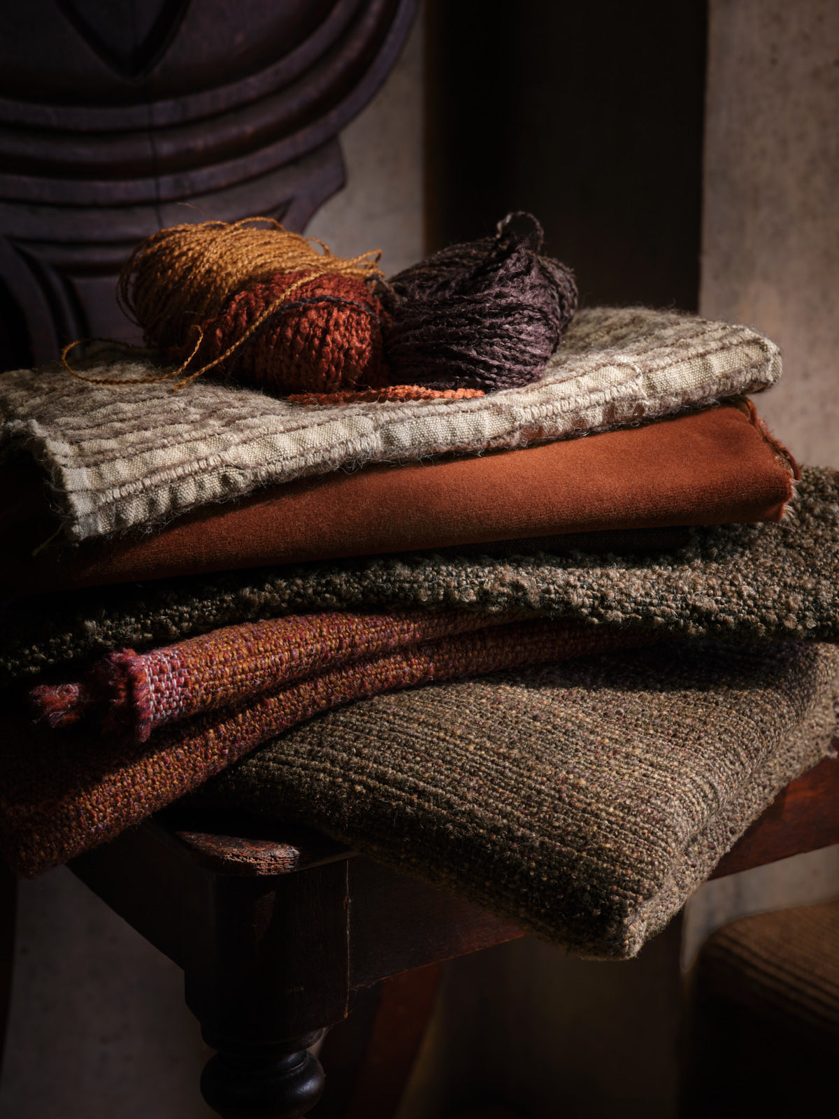 de Le Cuona fabrics—Nara Thistle, Merino Velvet Pumpkin, Attenborough Hyena, Strata Ember and Cinder—layered in interior.
