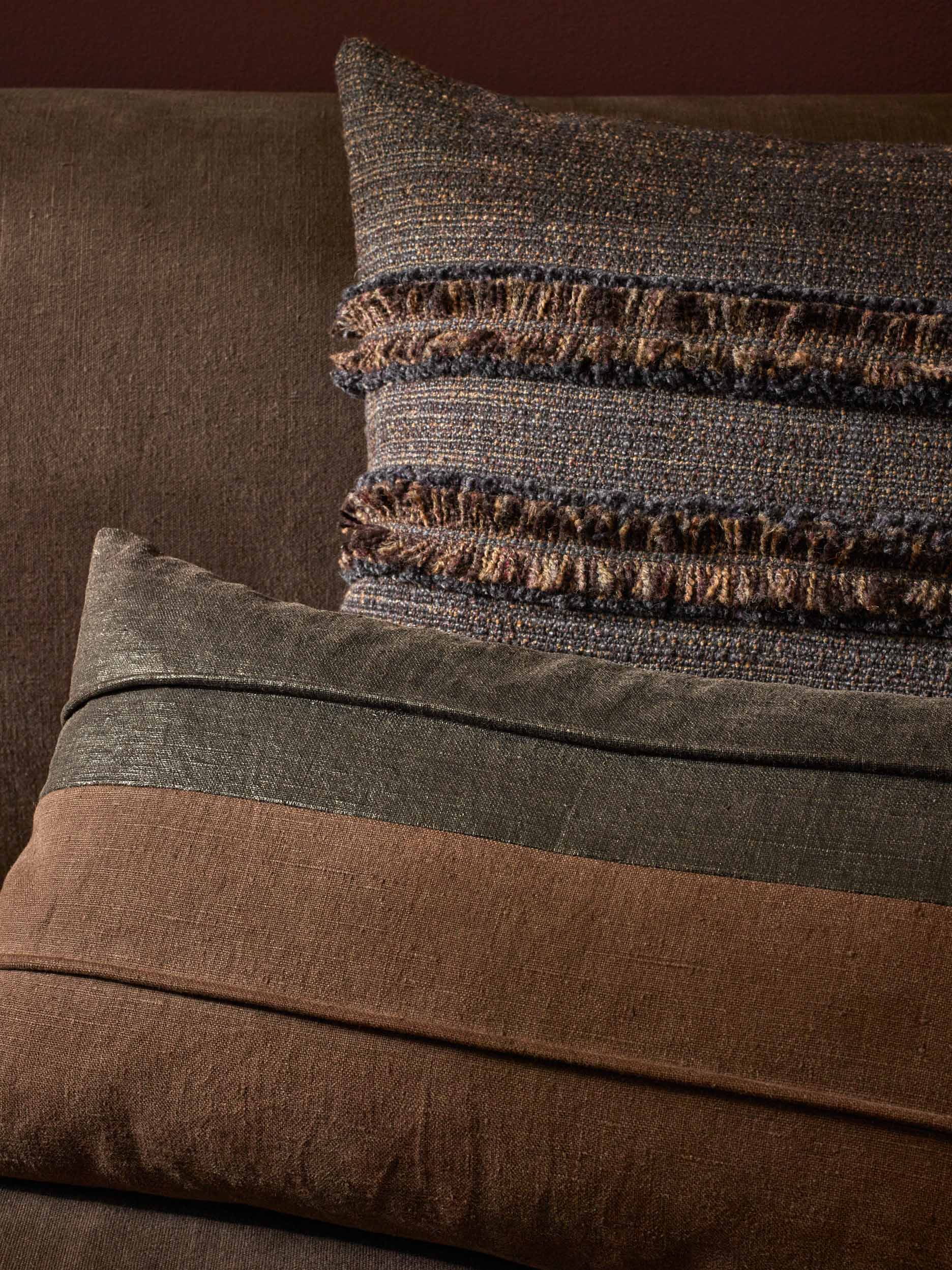 Close-up of textured pillows on a sofa with a focus on color and pattern.
